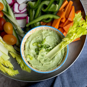 Pewter tray with a bowl of green goddess dip and chopped veggies.