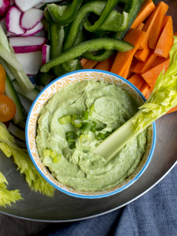 Pewter tray with a bowl of green goddess dip and chopped veggies.