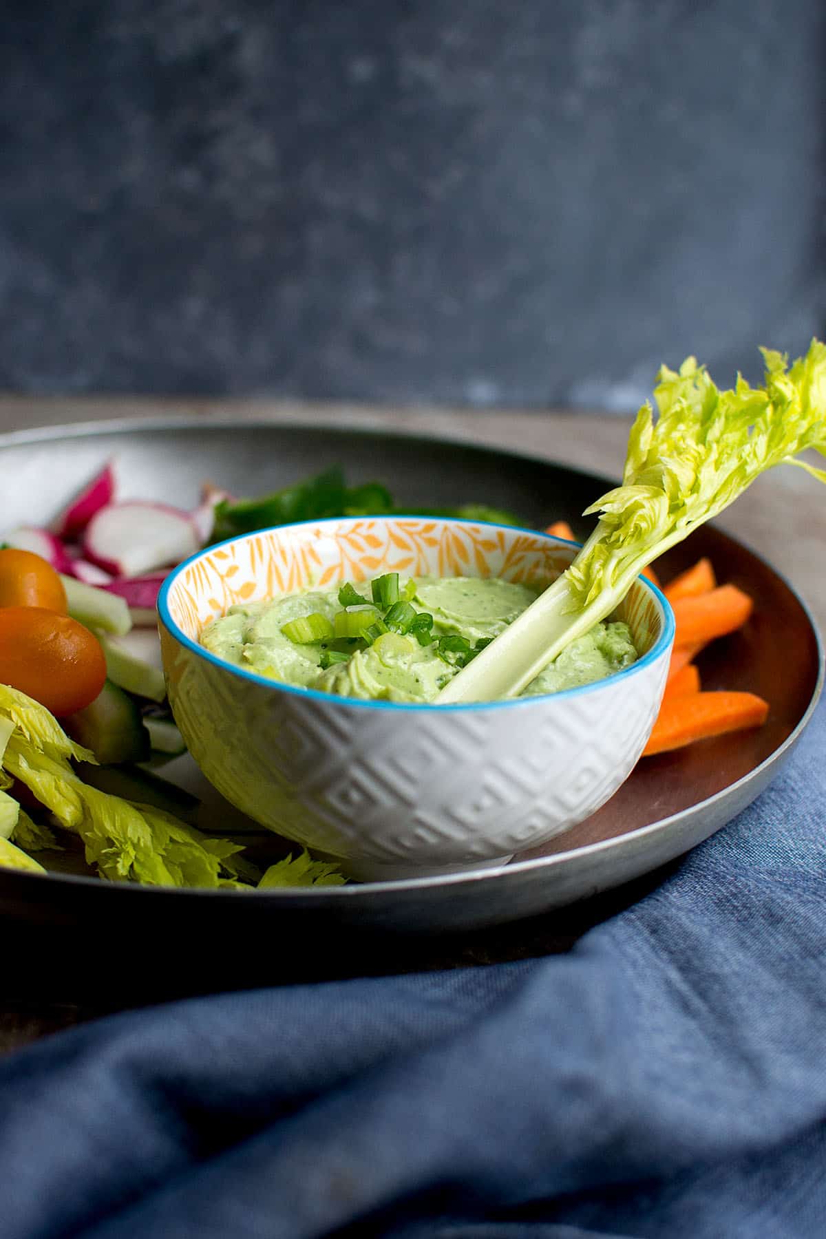 White bowl with green avocado dip.