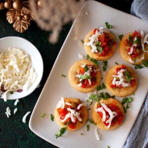 White plate with ritz crackers topped vegetable dip