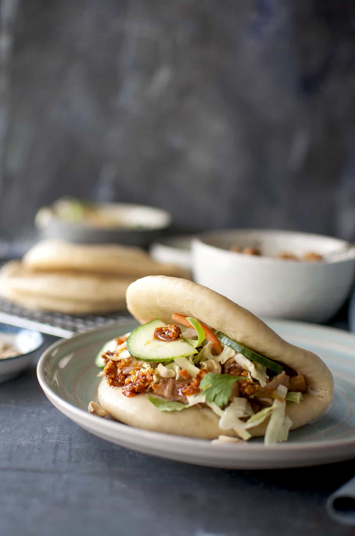 Blue plate with veggie filled vegan bao bun