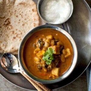 Tray with a bowl of paneer curry, roti and bowl of yogurt