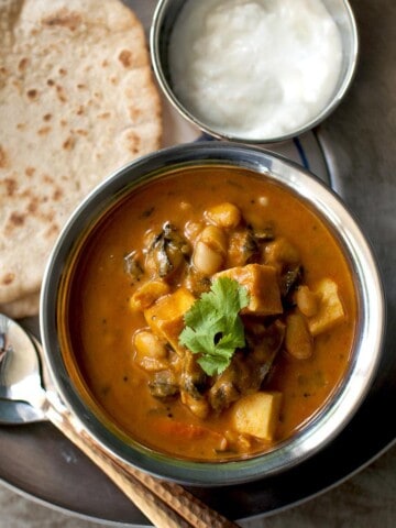 Tray with a bowl of paneer curry, roti and bowl of yogurt