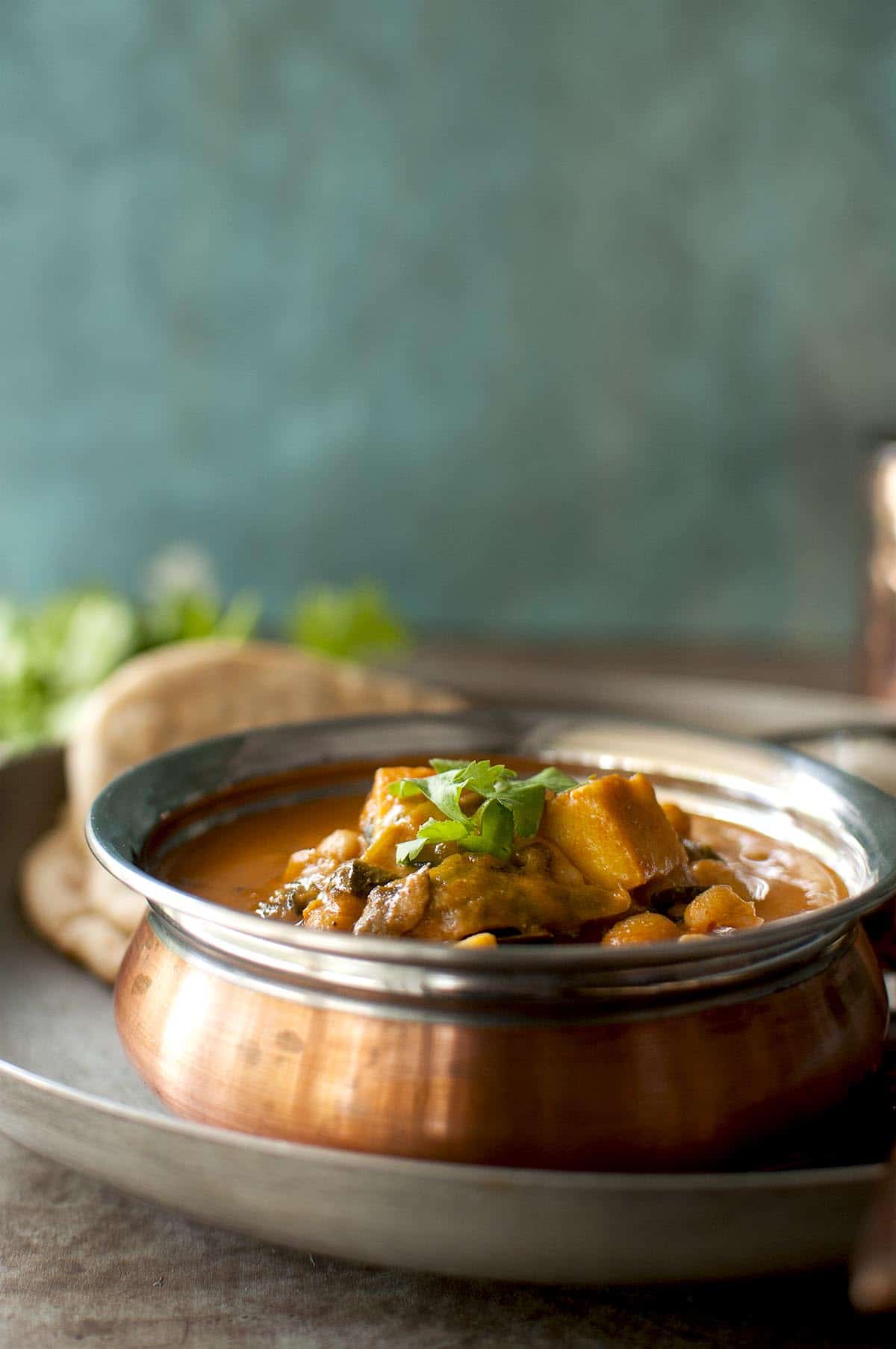 Copper bottom bowl with paneer curry with white beans