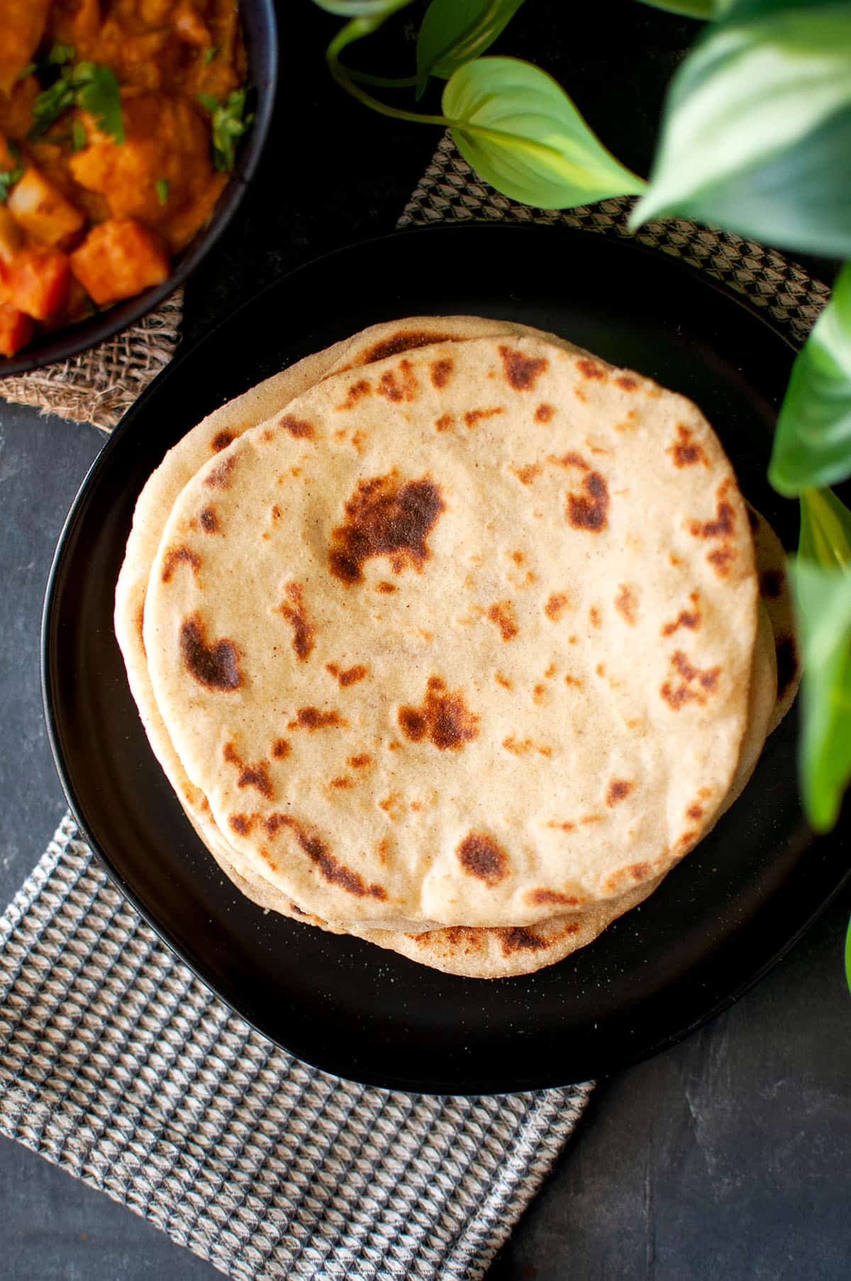 Top view of black plate with a stack of yoghurt flat bread.