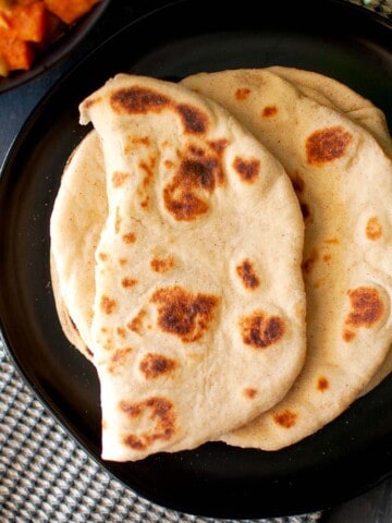 Black plate with soft flatbread.