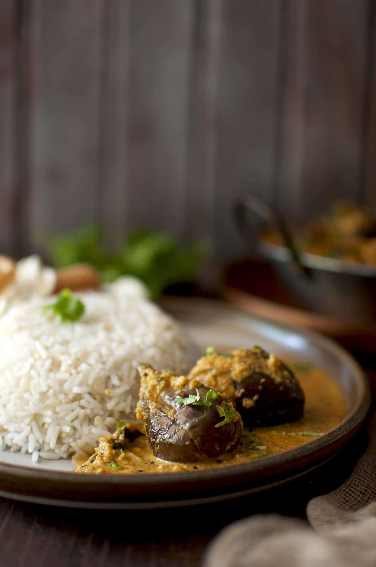 brown plate with bharwa baingan and rice.