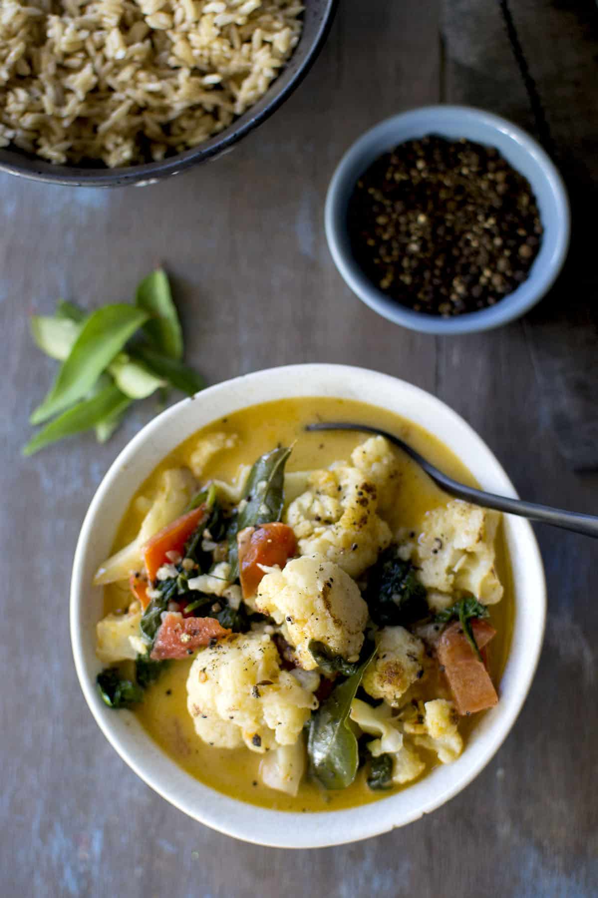 Grey bowl with cauliflower curry with coconut milk