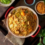 Top view of a red bowl with peanut noodles.