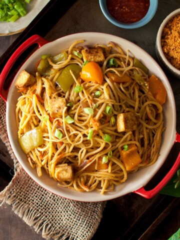 Top view of a red bowl with peanut noodles.