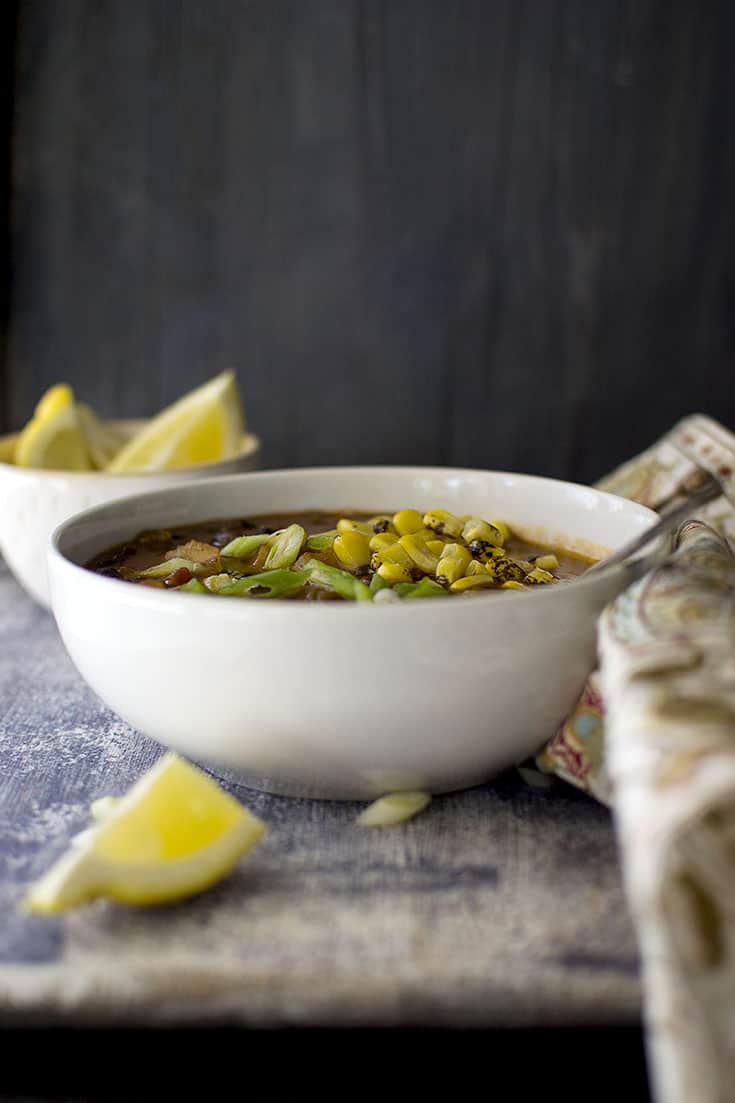 White bowl of soup with vegetables and black beans