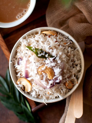 Top view of a white bowl with rice vermicelli topped with coconut.