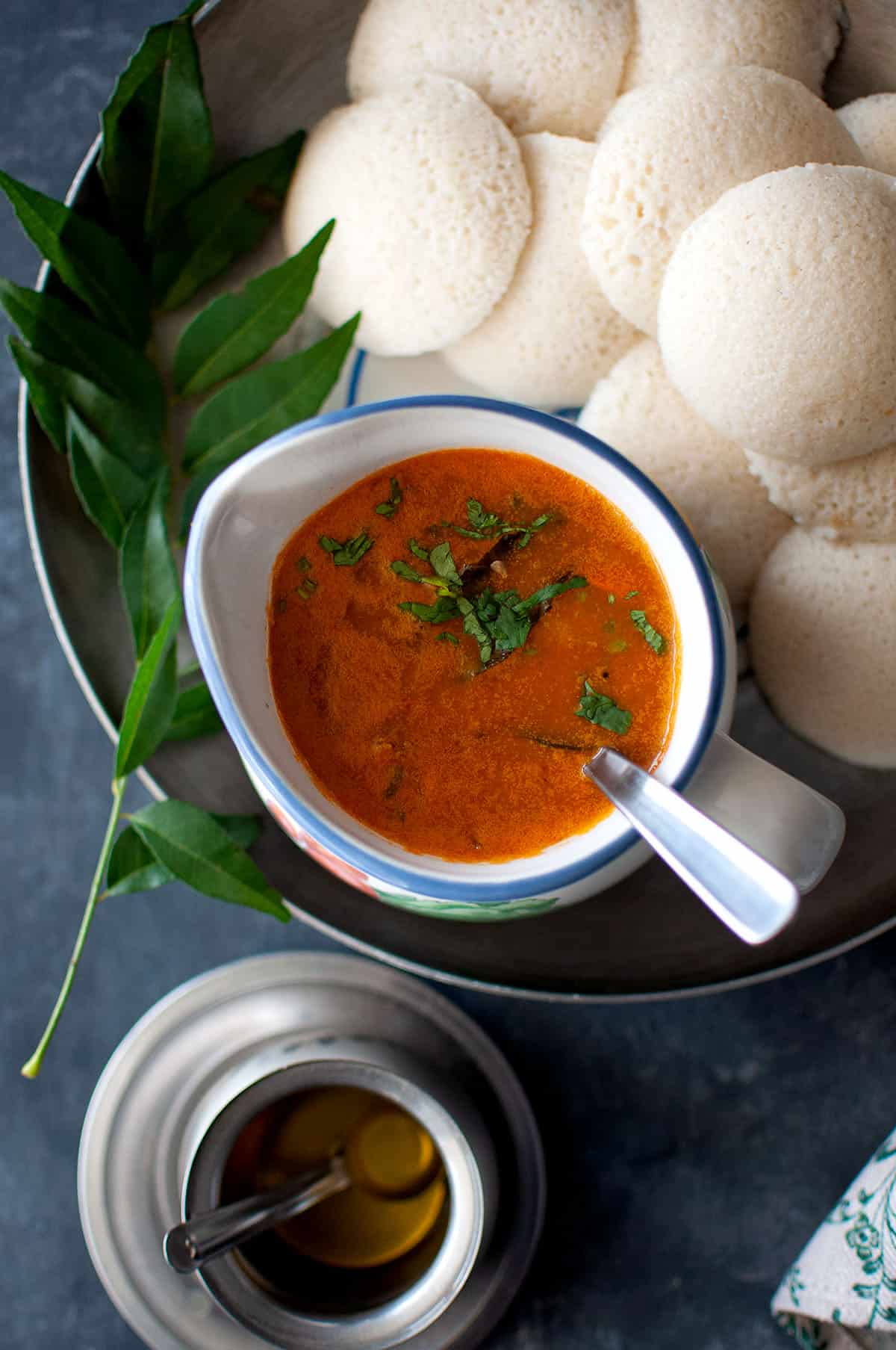 Top view of a bowl of sambar and idli.