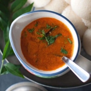 Top view of a bowl of sambar and idli.