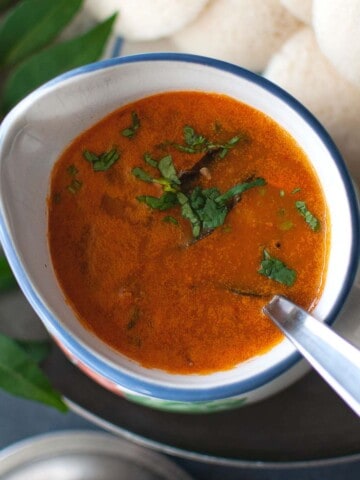 Top view of a bowl of sambar and idli.