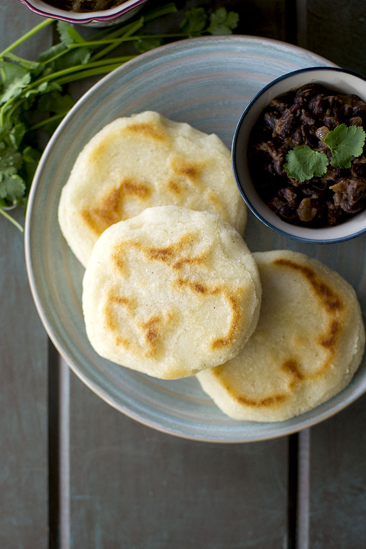 Blue plate with 3 arepa and black bean filling