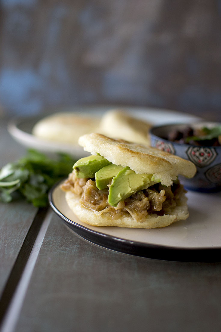 Black plate split Venezuelan vegan arepa filled with jackfruit