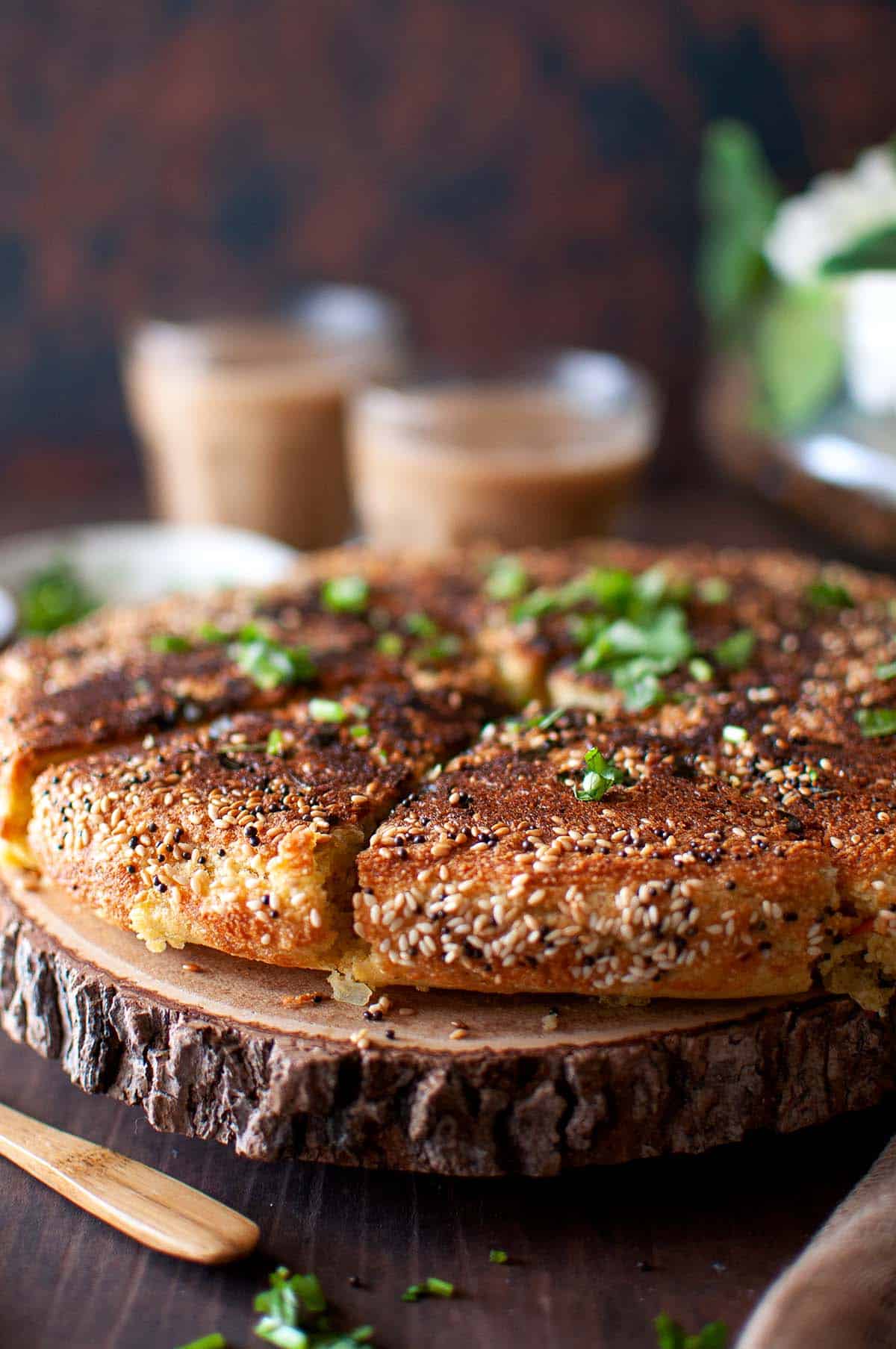 Wooden chopping board with sliced savory cake.