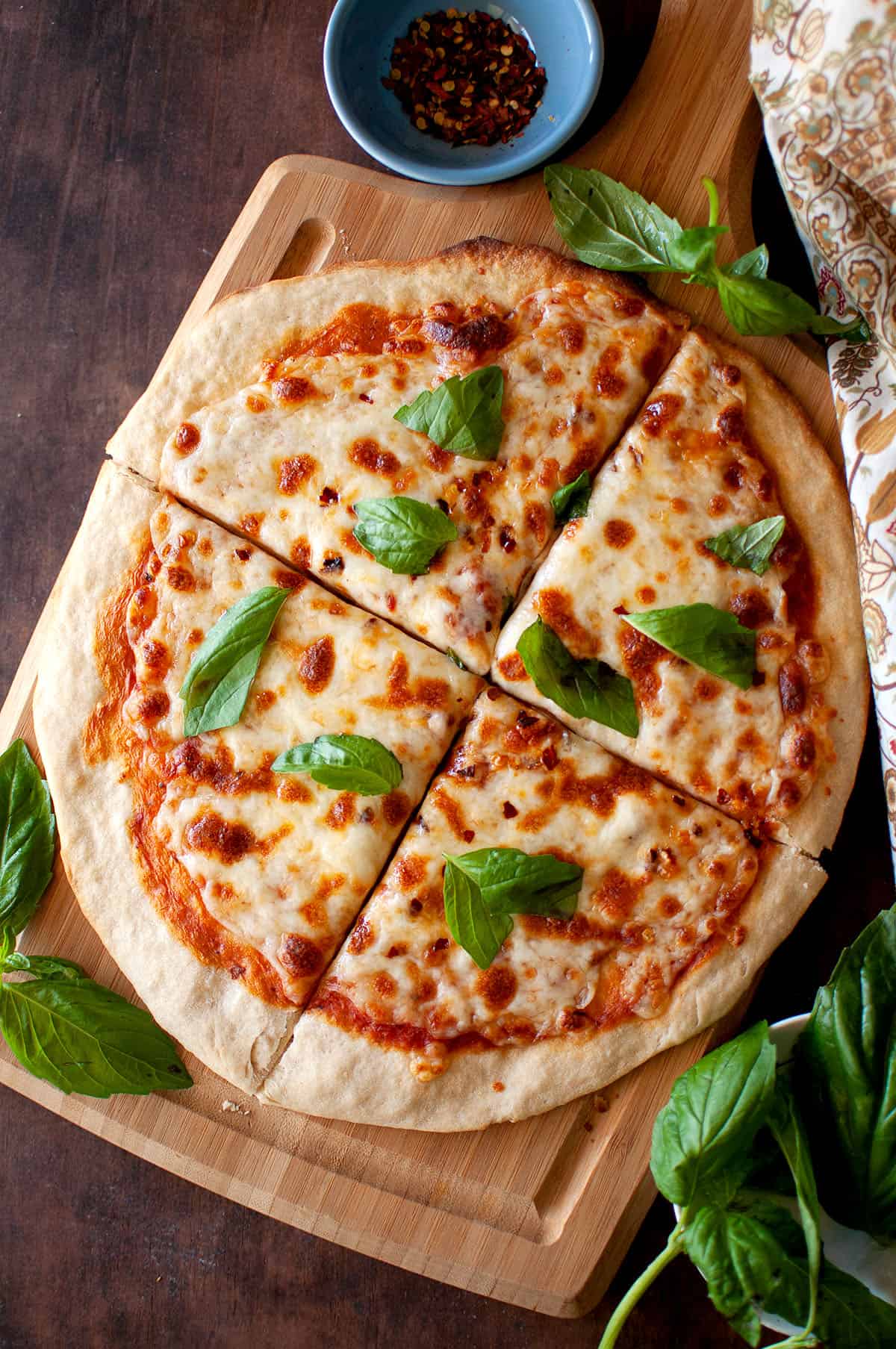 Wooden chopping board with no yeast cheese pizza.