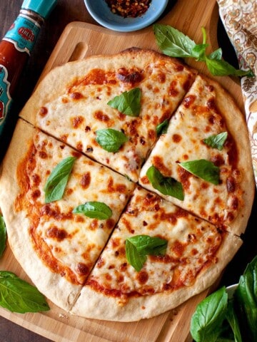 Wooden board with cheese topped flatbread.