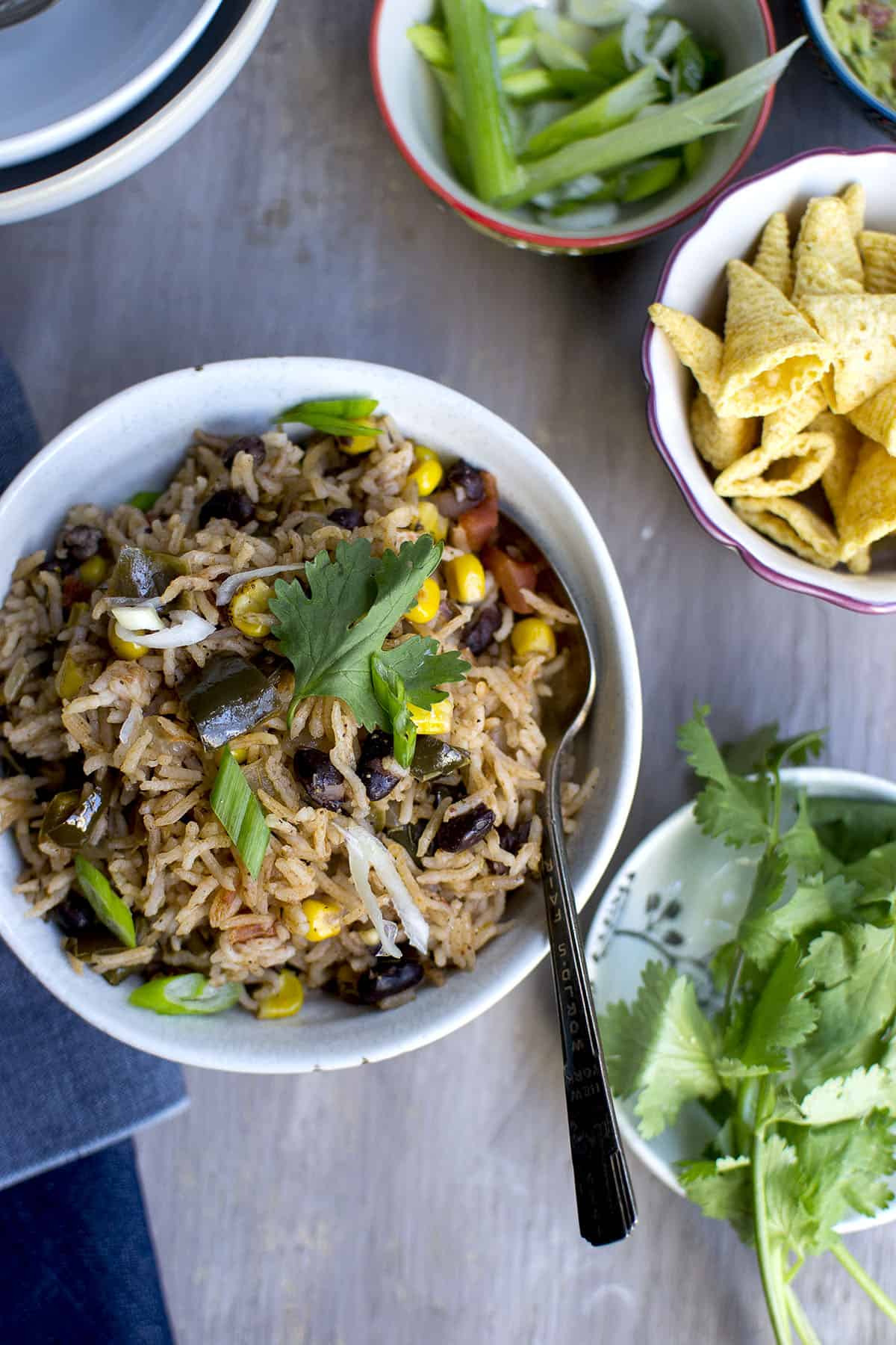 Grey bowl with rice and beans topped with cheese.