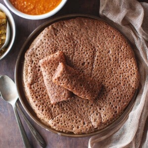 Brown plate with a stack of Ethiopian flatbread.