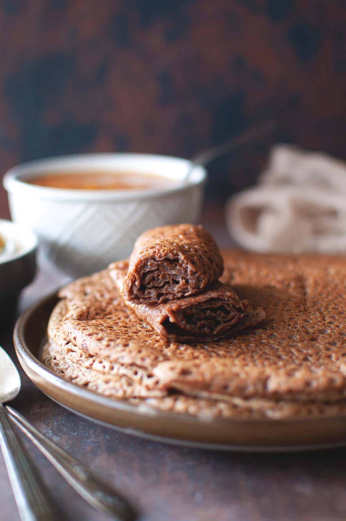 Brown plate with a stack of teff flatbread.