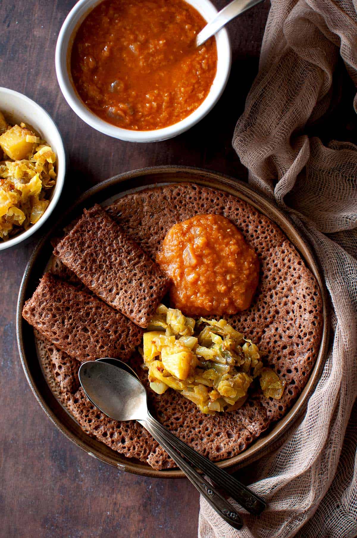 Blue plate with Ethiopian flatbread topped with dal and cabbage curry.