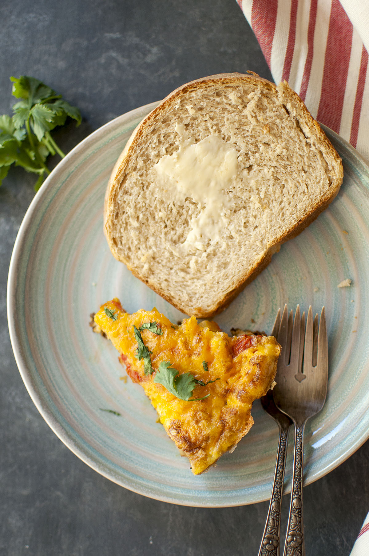 Blue plate with a wedge of vegetable frittata and buttered toast