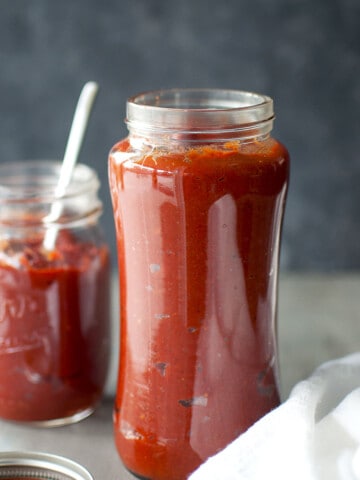 glass jars with vibrant red tomato achar