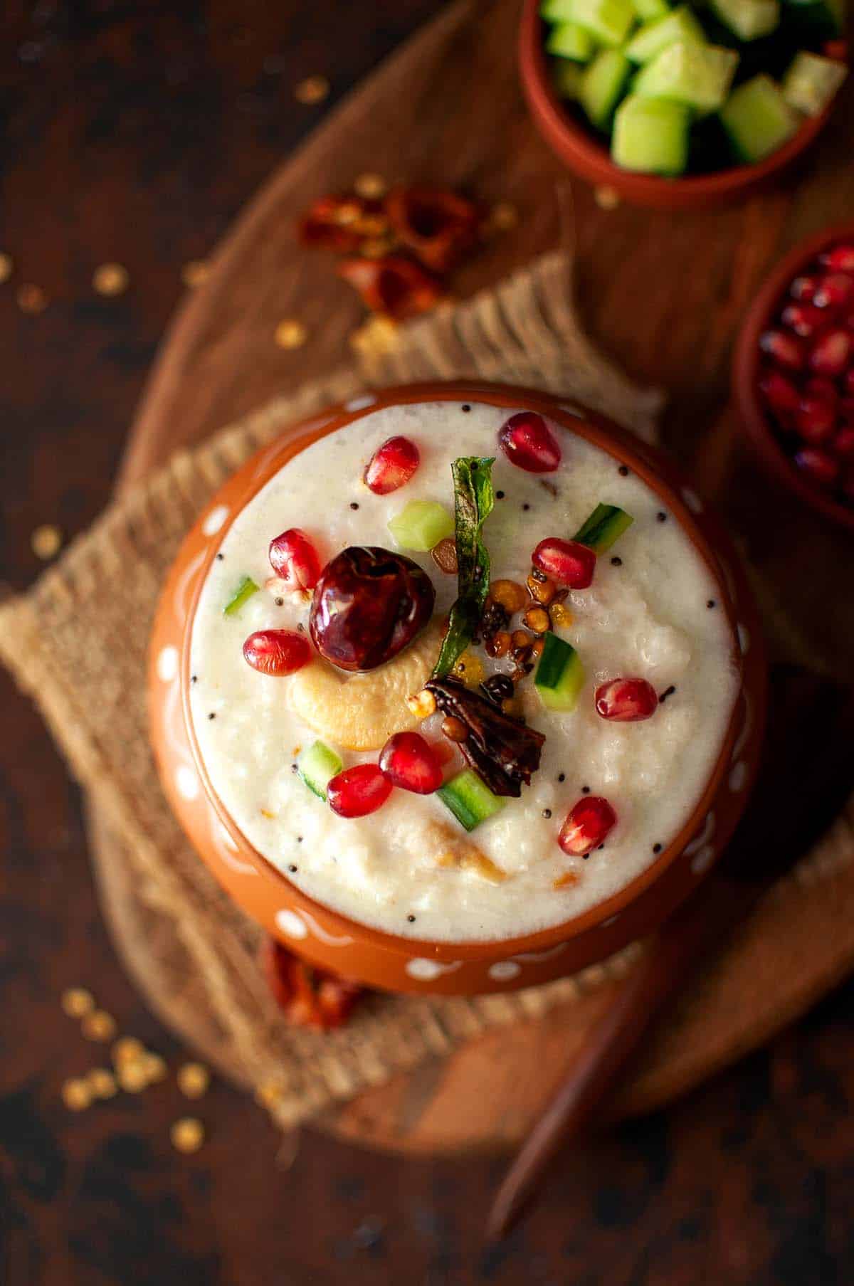 Terracotta bowl with yogurt rice topped with pomegranate arils.