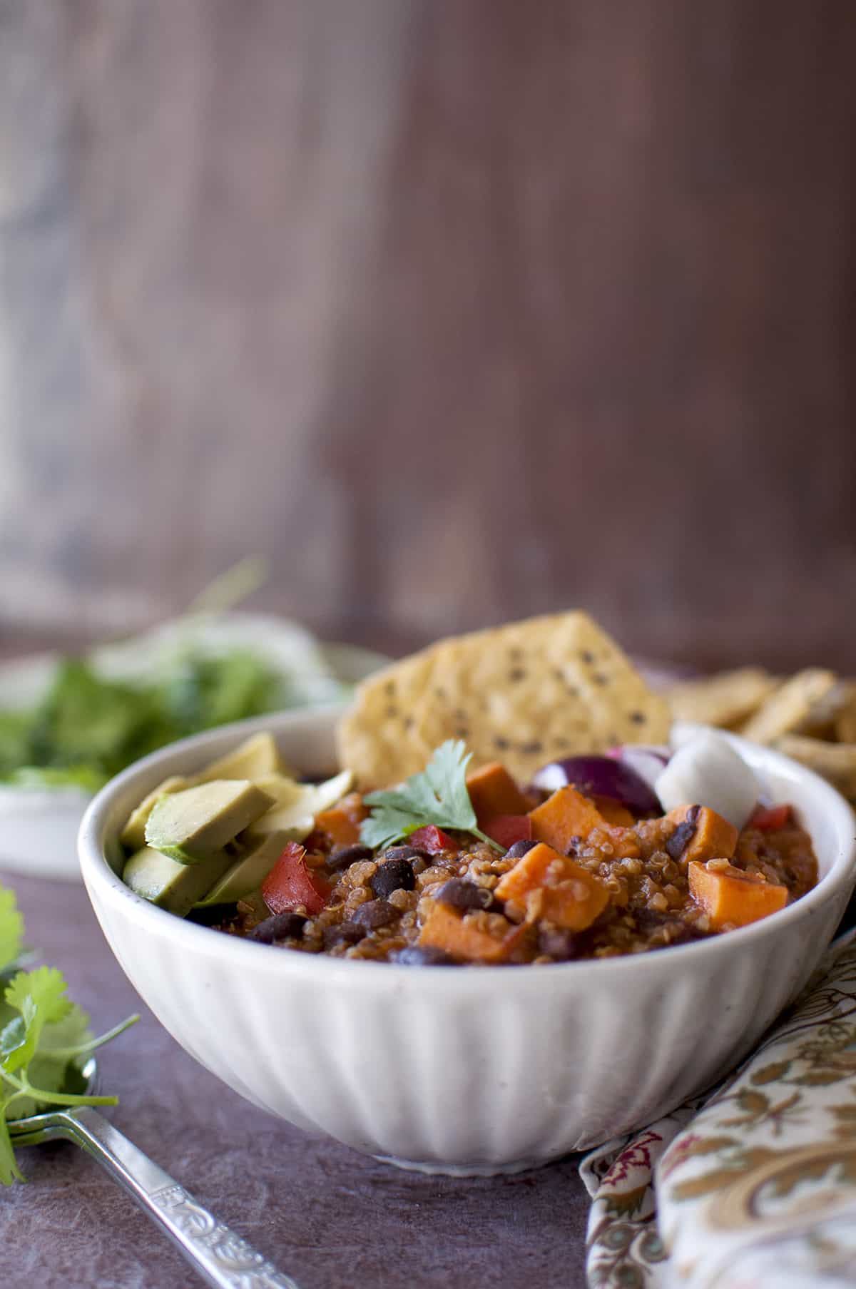 White bowl with quinoa chili with toppings