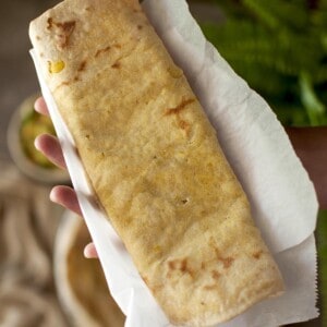 Hand holding a folded Dholl puri