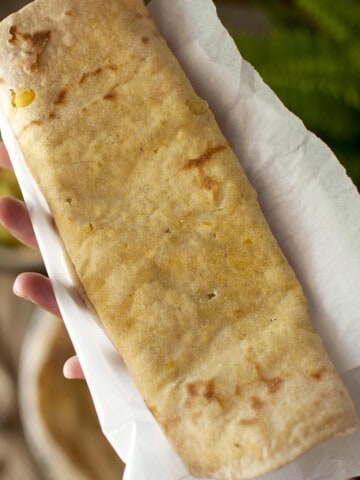 Hand holding a folded Dholl puri