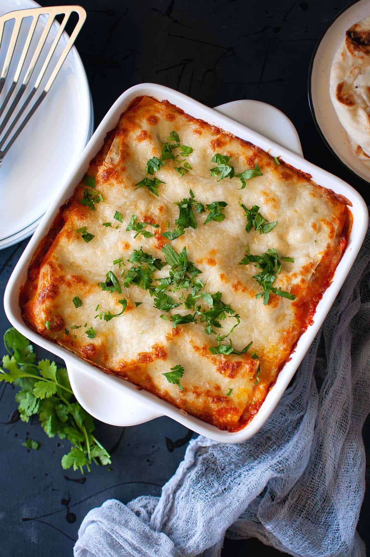 White Baking pan with cheese topped Paneer Lasagna