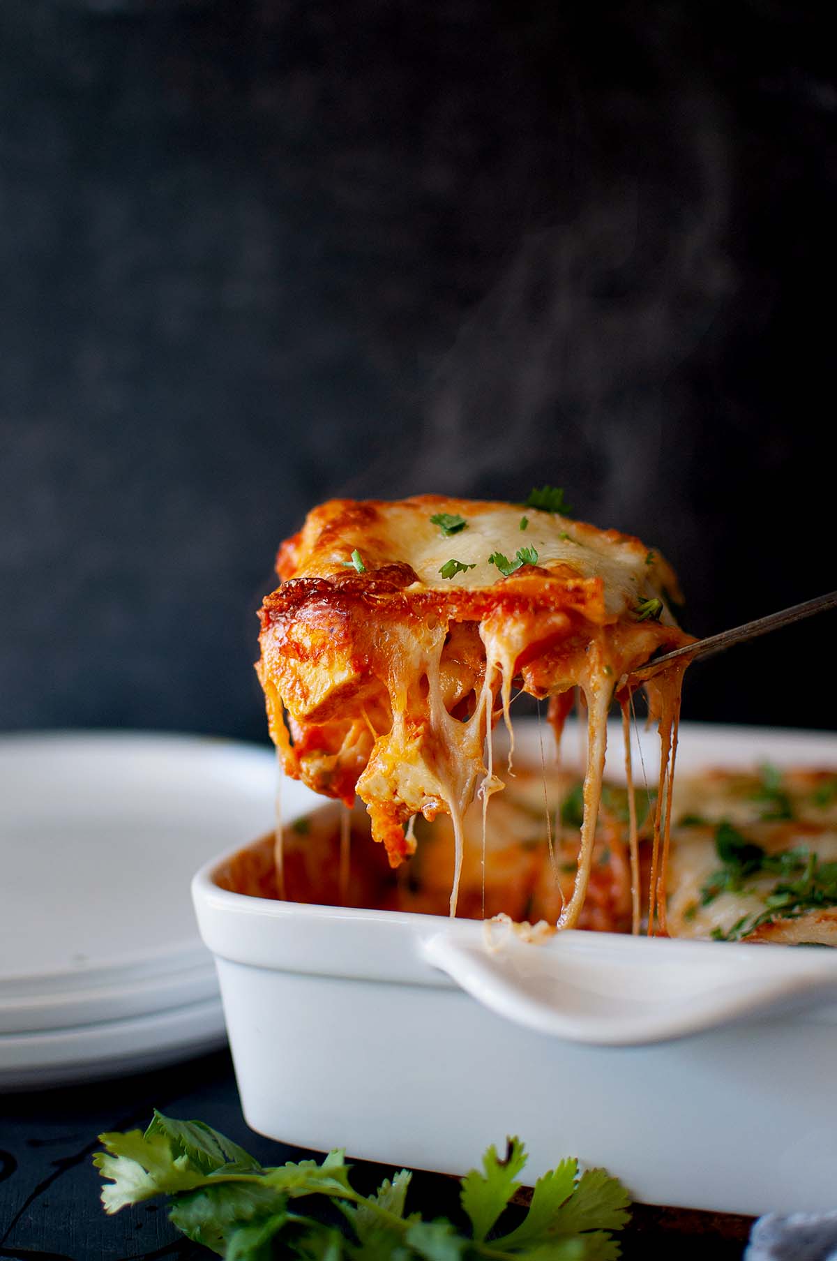 Spoon lifting a slice of lasagne