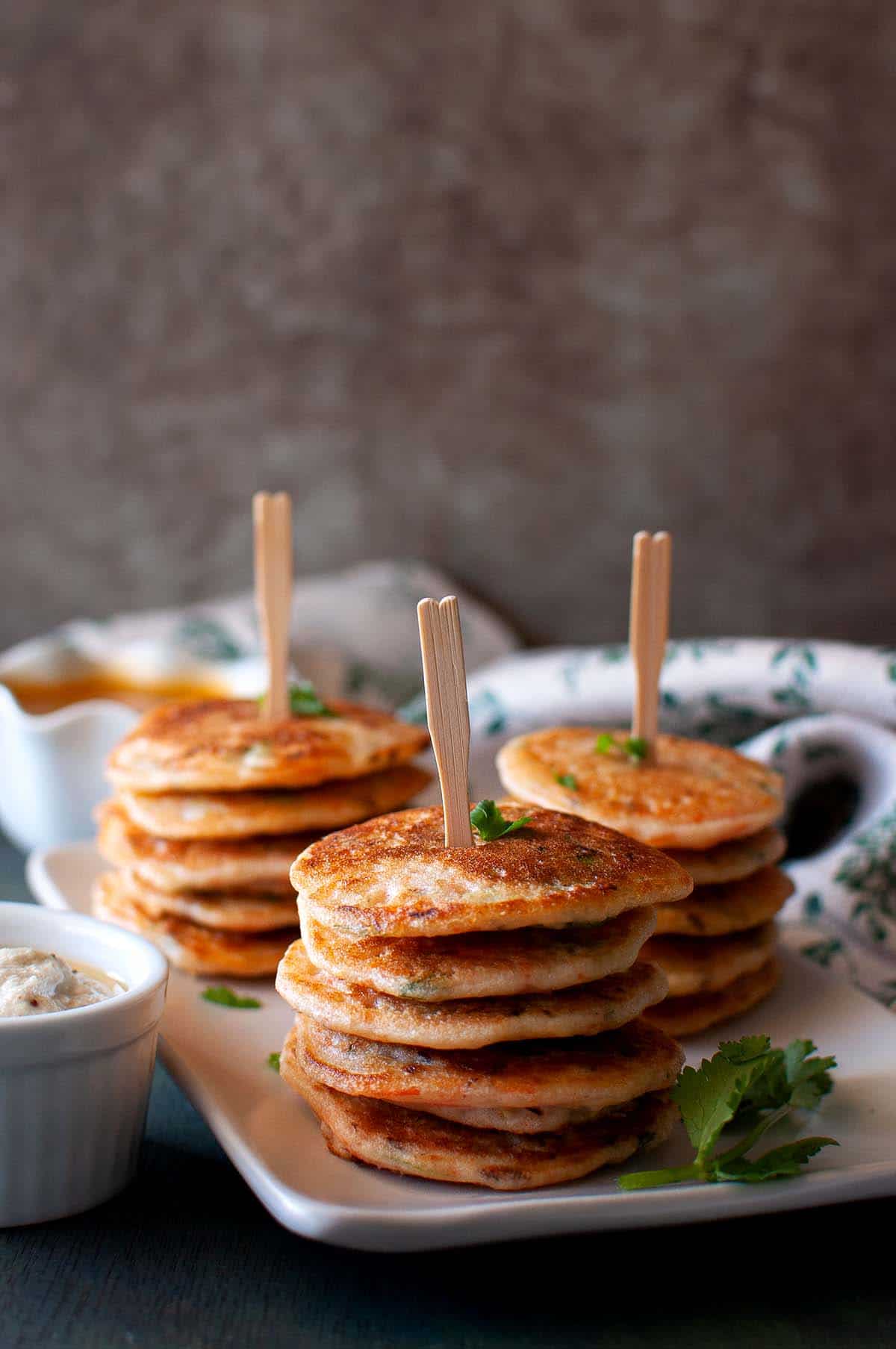 White plate with 3 stacks of vegetable uttapam.