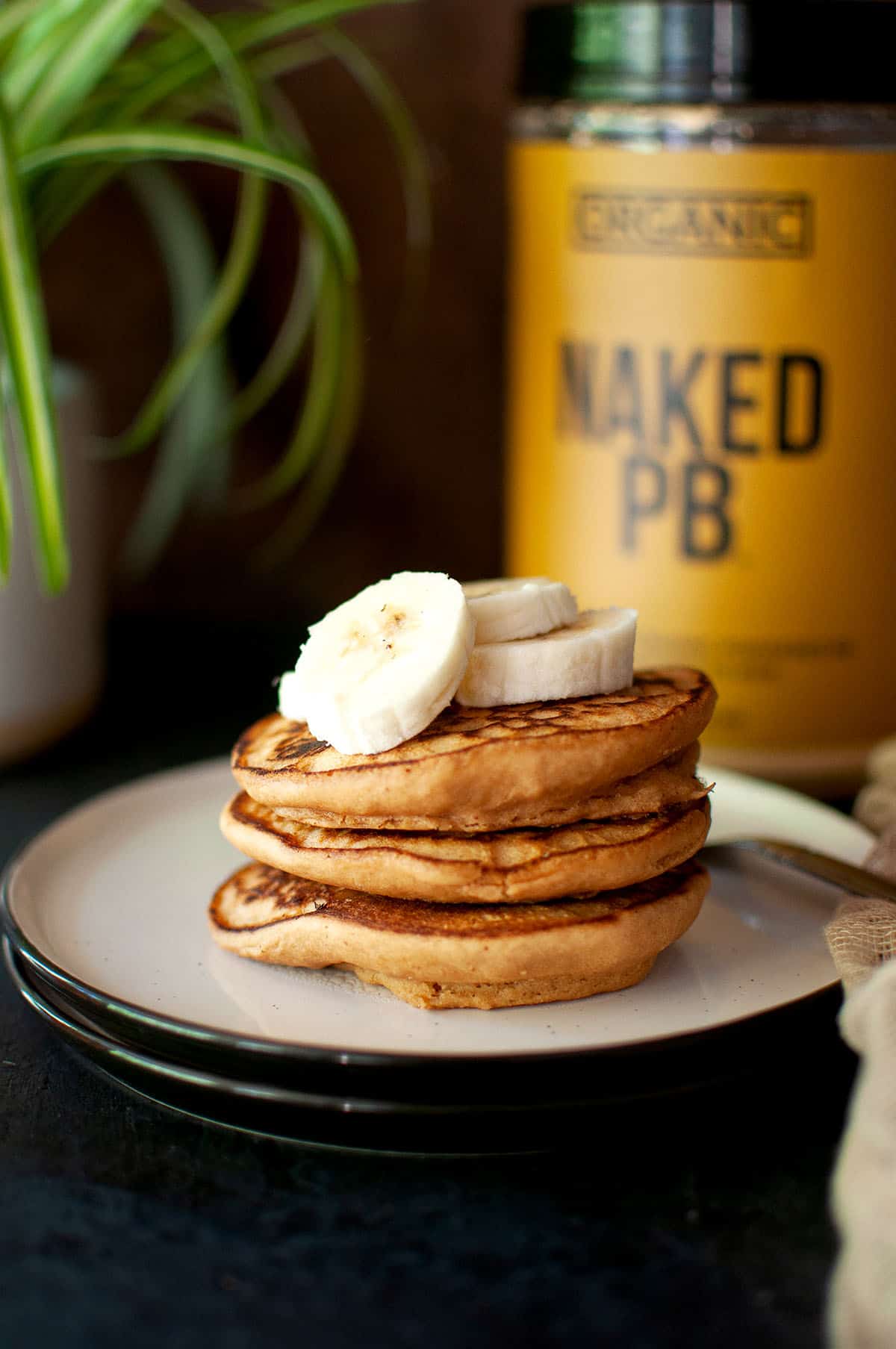 White plate with a stack of vegan peanut butter protein pancakes.